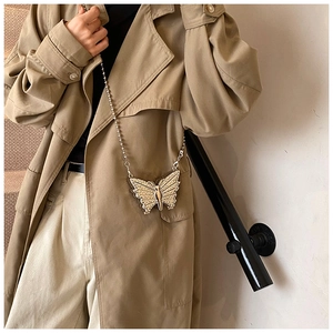Vue détaillée du sac papillon de soirée avec perles incrustées et chaîne dorée fine