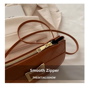Détail du sac bandoulière marron matelassé montrant le zip doré et les coutures fines