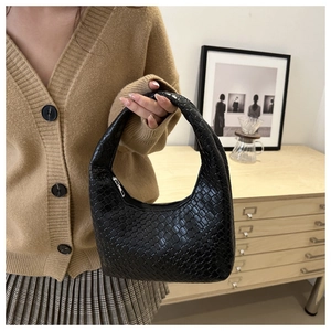 Detail view of black woven leather hobo bag with moon silhouette and seamless top handle
