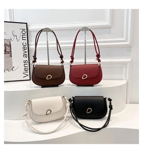 Saddle bag detail showcasing four colors with a unique knotted strap and gold hardware