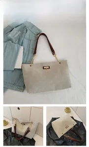 Detail of woven tote bag featuring brown leather straps and gold metal deer pendant