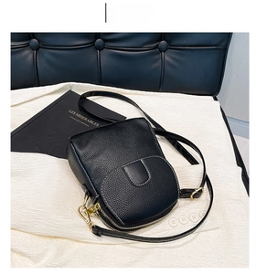 Close-up of black litchi grain texture bag with white stitching and gold hardware