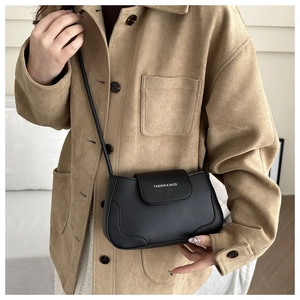 Detail of a black leather crossbody bag with Fashion & Bags print on a khaki coat