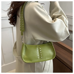 Gros plan du sac porté épaule vert herbe avec des rivets argentés et texture en cuir