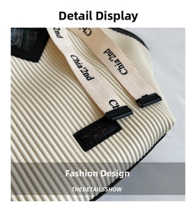 Detailed close-up of white corduroy texture and branded leather patch on a tote bag