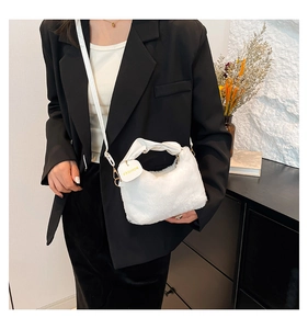 Detail of white plush handbag with leather knotted handle and yellow fashion tag