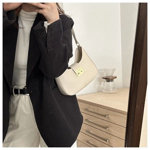 Detail of minimalist cream leather underarm bag with elegant gold metal square buckle lock