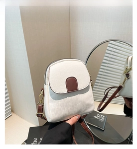 Close-up of white lychee pattern PU leather crossbody bag with brown accent and gold buckle