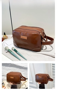 Détail d'une trousse de toilette en cuir PU marron avec trois fermetures et poignée latérale