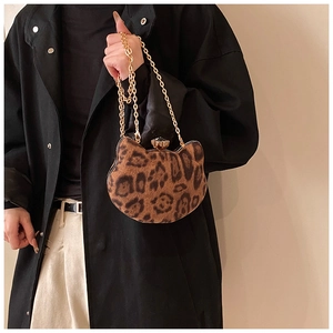 Detail of leopard print cat-shaped mini bag with gold chain and gem-set clasp