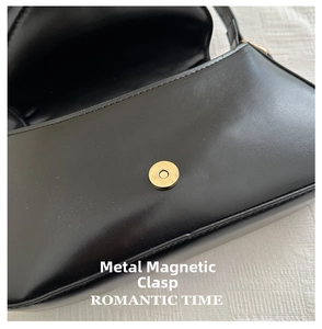 Close-up of magnetic snap closure and texture on black vintage leather hobo bag