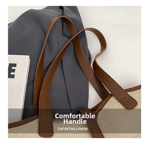 Gros plan d'un cabas en toile blanc cassé avec des poignées en cuir marron et texture fine