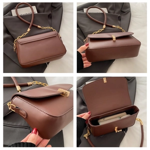 Detail view of the brown leather crossbody bag with chain strap and gold hardware