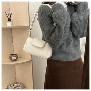 Detailed side view of a white minimalist underarm bag featuring a knotted thin shoulder strap