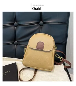 Detail of khaki pebbled leather mini crossbody bag with golden metal hardware hooks