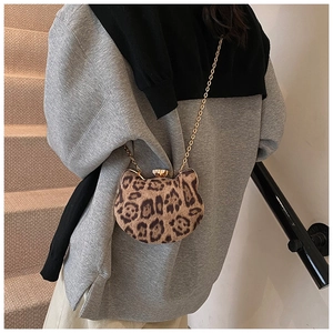 Detail of leopard print cat-shaped crossbody bag with gold chain and plush texture