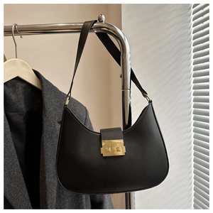 Close-up of black crescent shoulder bag with gold metal clasp and leather texture