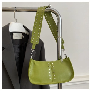 Vue détaillée du sac baguette en cuir vert avec rivets argentés et large bandoulière