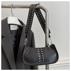 Détail du cuir grainé avec rivets argentés sur ce sac sous le bras noir de style rétro chic