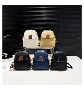 Close-up of five stylish mini crossbody bags in assorted colors with litchi grain texture