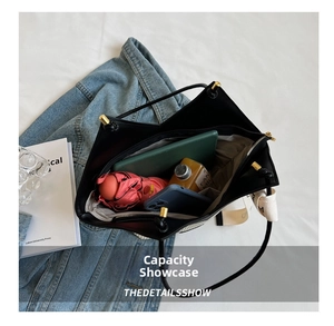 Spacious interior of a black leather tote bag with compartments for essentials