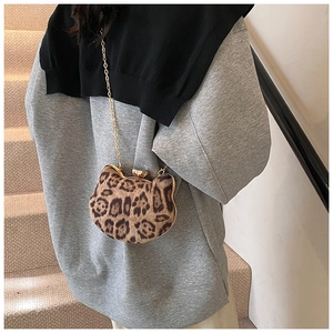 Detail of leopard print crossbody bag with cat head shape and gold metal chain strap
