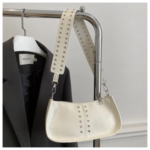 Détail du sac à bandoulière blanc avec rivets argentés et large sangle en cuir