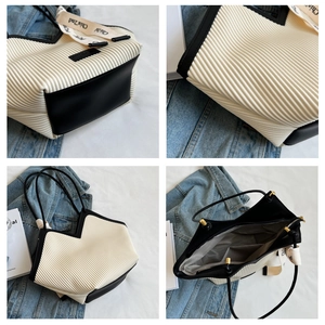 Detail view of large tote bag showing textured pleats, inner lining and zip pocket