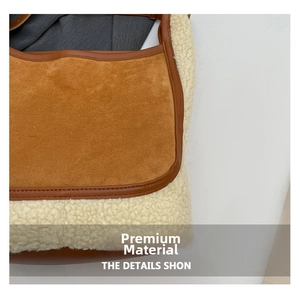 Détail du sac seau en peau de mouton contrastée avec daim brun et texture laine crème