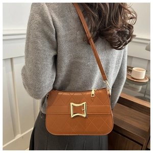 Détail du sac bandoulière matelassé caramel avec boucle dorée et lanière en cuir