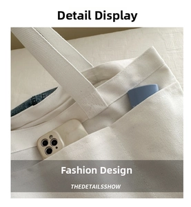 Detail view of large white canvas tote bag showing double exterior pockets and spacious interior