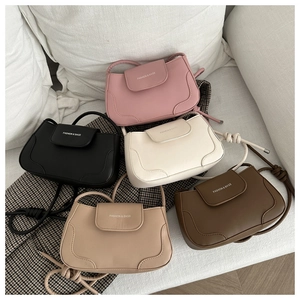 Detail view of stylish underarm bags in five colors with engraved fashion lettering