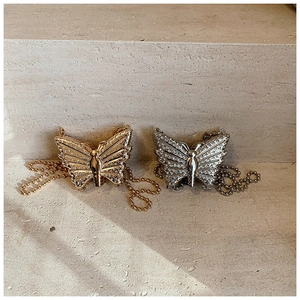 Macro detail of gold and silver butterfly hardware with sparkling rhinestones