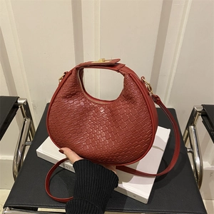 Chic red woven leather crescent bag with adjustable shoulder strap and gold hardware