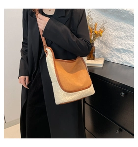 Détail du sac seau bicolore en peluche et daim porté par un mannequin en veste
