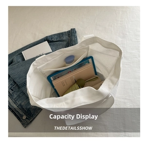 Interior view showing the large storage capacity of the white canvas tote bag with a pocket