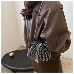 Detail der schwarzen Strass-Beuteltasche mit Silberkette und Perlenverzierung