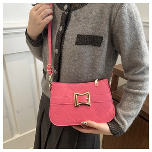 Détail du sac bandoulière rose matelassé avec boucle carrée dorée sur une tenue chic