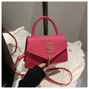 Detail of rose pink leather bag with gold double-S logo and elegant tassel charm