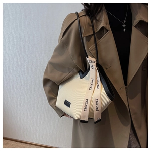 Detailed view of the French pleat tote bag with black contrast trim and tie decoration