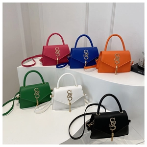 Detail of six colorful handbags with metal SCS logo and tassels on a tiered stand