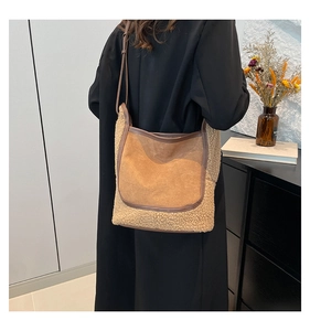 Détail du sac seau en suédine avec bordure en peau de mouton porté à l'épaule avec style