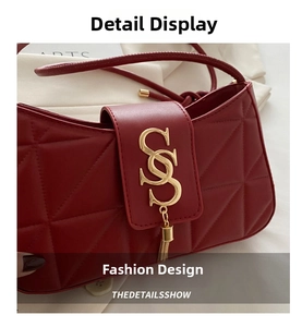 Close-up of red quilted leather bag featuring a gold metal S logo and tassel detail