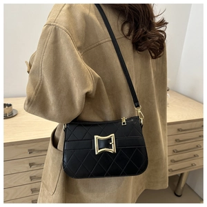 Gros plan sur un sac porté épaule matelassé noir avec boucle dorée sur un mannequin