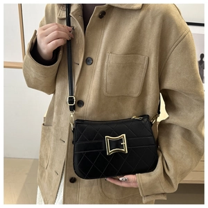Gros plan d'un sac à bandoulière matelassé noir avec détail de boucle dorée vintage