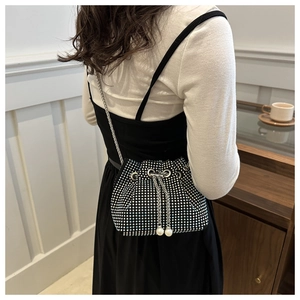 Detail einer schwarzen Strass-Beuteltasche mit Perlenquasten und silberner Metallkette