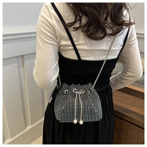 Rückansicht eines Models mit Strass-Beuteltasche, Perlen-Kordelzug und Kettenriemen