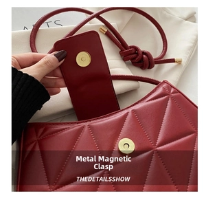 Detail of golden magnetic snap closure and quilted red leather texture on shoulder bag