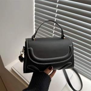 Minimalist black crossbody bag with white contrast stitching and top handle design