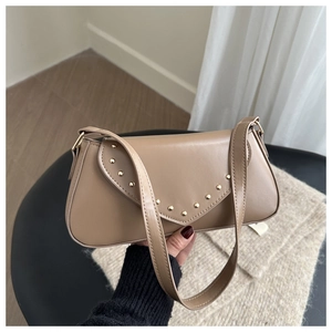 Detail of khaki PU leather underarm bag featuring V-shaped flap and gold rivet trim